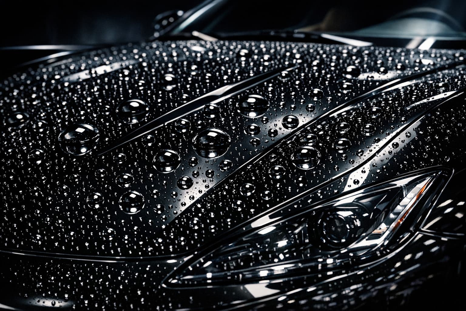 Water beading on ceramic-coated black luxury car hood