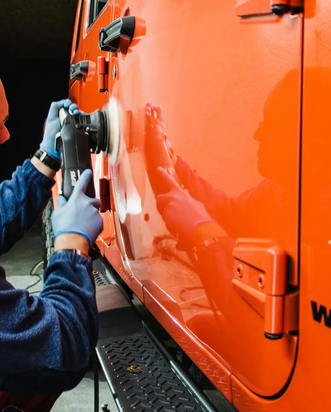 Paint correction on an orange Jeep door panel